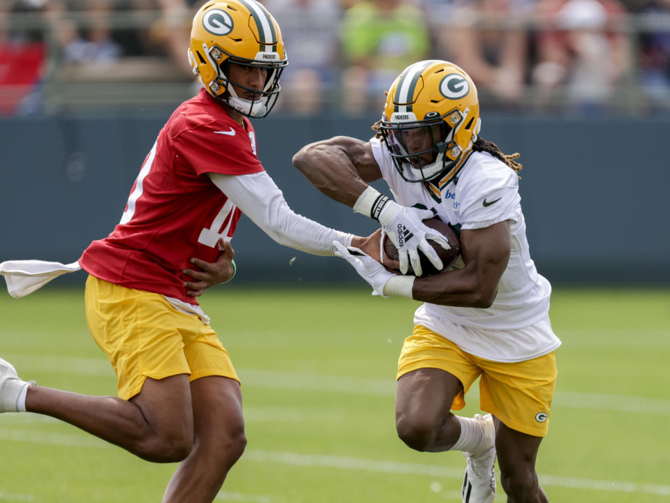 Green Bay Packers' quarterback Jordan Love hands the ball off to running back Aaron Jones during NFL football training camp Wednesday, July 28, 2021, in Green Bay, Wis. (AP Photo/Matt Ludtke)