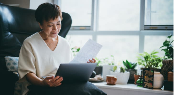 A woman looks over a Roth IRA when she wonders if she can retire at age 62.