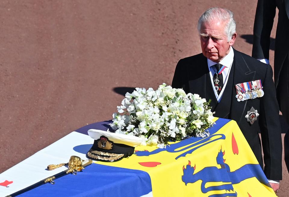 prince charles stands behind prince philip's coffin