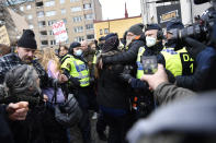 Anti-lockdown protesters face police as they demonstrate against coronavirus restrictions in Stockholm Saturday March 6, 2021. The protest was disbanded by police due to lack of permit for the public gathering. (Henrik Montgomery / TT via AP)