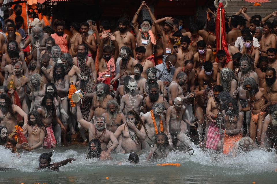 Naga Sadhus (Hindu holy men) take a holy dip in the waters of the Ganges River on the day of Shahi Snan (royal bath) during the ongoing religious Kumbh Mela festival, in Haridwar on April 12, 2021. (Photo by Money SHARMA / AFP) (Photo by MONEY SHARMA/AFP via Getty Images)