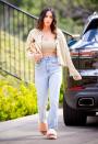 <p>The star wore a pair of peach-coloured UGG sliders, jeans, a beige-hued crop top and knitted cardigan from Urban Outfitters while out in Los Angeles. </p>