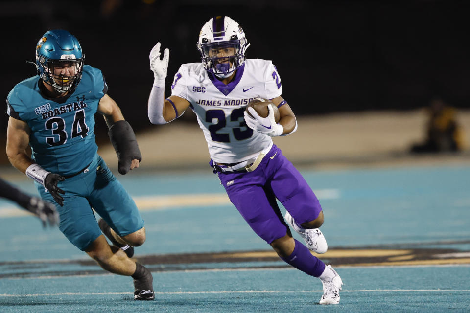 James Madison running back Sammy Malignaggi (23) carries the ball ahead of Coastal Carolina linebacker Wyatt Gedeon (34) during the second half of an NCAA college football game in Conway, S.C., Saturday, Nov. 25, 2023. (AP Photo/Nell Redmond)