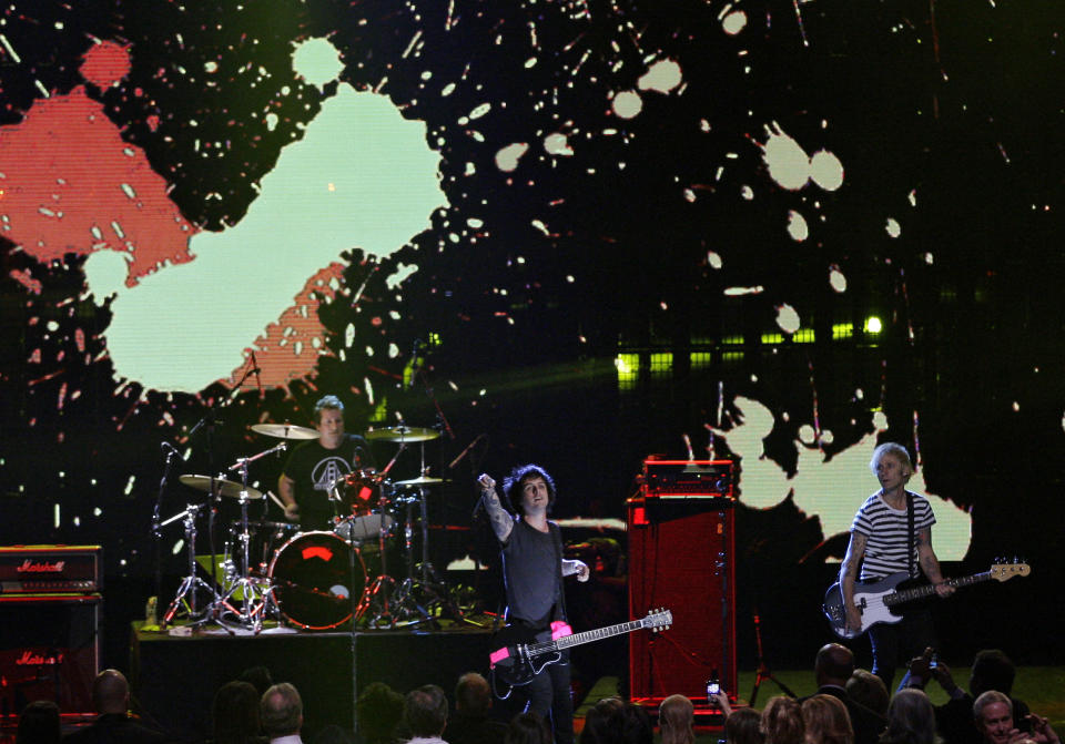 Green Day (from left) Tre Cool, Billy Joe Armstrong and Mike Dirnt, performs to open the 2012 Rock and Roll Hall of Fame induction ceremonies Saturday, April 14, 2012, in Cleveland. Green Day introduce Guns N' Roses for induction into the Rock and Roll Hall of Fame. (AP Photo/Tony Dejak)