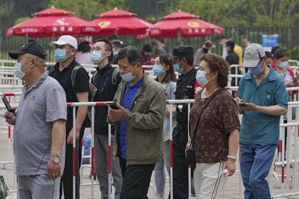 Residents wearing face masks to help curb the spread of the coronavirus line up to receive the Sinopharm COVID-19 vaccine at the Central Business District in Beijing, Wednesday, June 2, 2021. (AP Photo/Andy Wong)