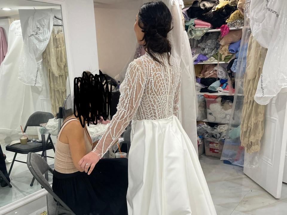 Pepa trying on the custom wedding dress, with the back facing the camera