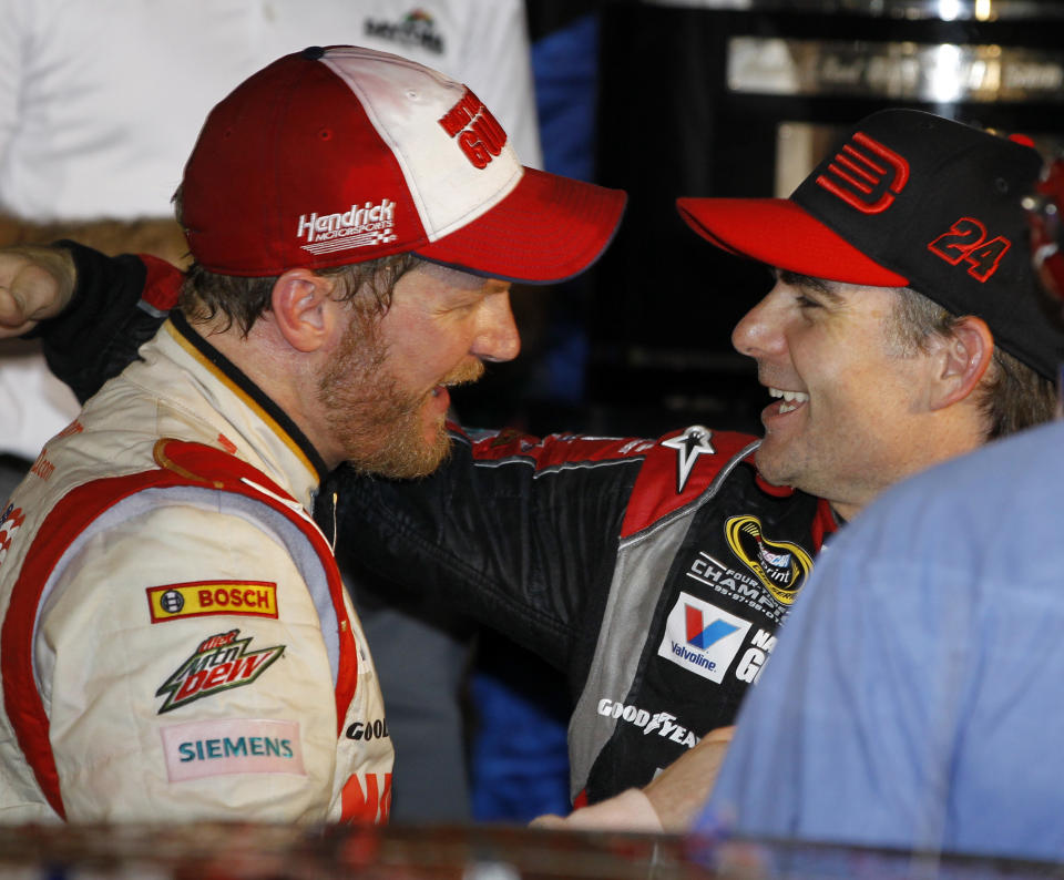 Dale Earnhardt Jr., left, celebrates in Victory Lane with teammate Jeff Gordon, right, after winning the NASCAR Daytona 500 Sprint Cup series auto race at Daytona International Speedway in Daytona Beach, Fla., Sunday, Feb. 23, 2014. (AP Photo/Terry Renna)