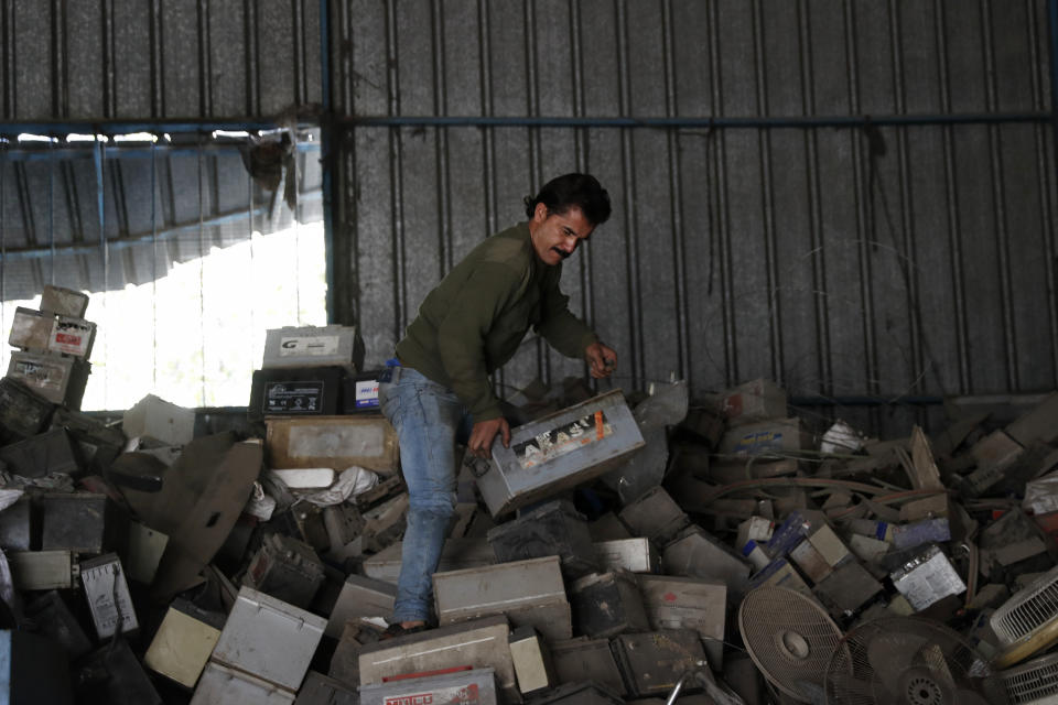 A Palestinian worker carries a discarded battery at a warehouse in Jebaliya, Gaza Strip, Wednesday, Dec. 15, 2021. In a territory suffering from chronic power outages, batteries are needed to keep most Gaza households running. But huge mounds of used batteries are piling up at makeshift outdoor landfills, posing a threat to public health and the environment. (AP Photo/Adel Hana)