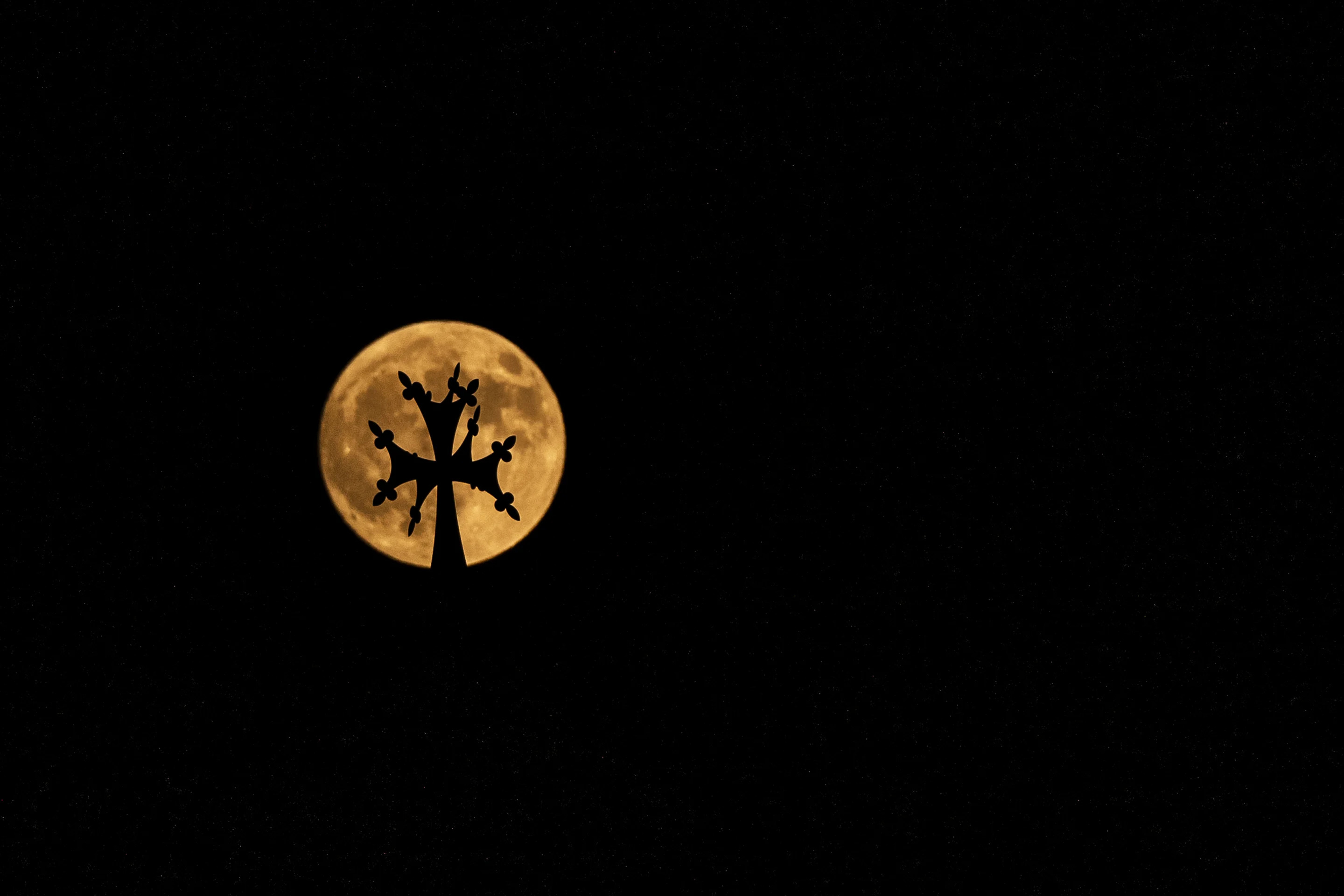 The supermoon rises beyond the cross atop Saint Elias and Saint Gregory the Illuminator Armenian Catholic Cathedral, in Beirut on Tuesday.