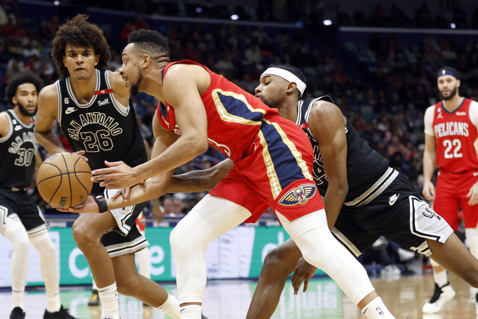 New Orleans Pelicans guard CJ McCollum (3) is fouled by San Antonio Spurs guard Blake Wesley (14) in the first half of an NBA basketball game in New Orleans, Tuesday, March 21, 2023. (AP Photo/Tyler Kaufman)