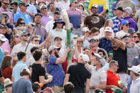 Fans on the 16th hole try to put together a cup snake during the final round of the Phoenix Open golf tournament, Sunday, Feb. 12, 2023, in Scottsdale, Ariz. (AP Photo/Darryl Webb)