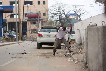A man raises his hands as he runs from the scene of a suicide bomb attack outside Nasahablood hotel in Somalia's capital Mogadishu, June 25, 2016. REUTERS/Feisal Omar