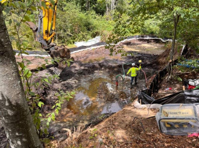 Pictured are dewatering and excavation activities within a contaminated sediment area at the Plaistow Beede Waste Oil Superfund site, where mismanagement and spills led to widespread PCB contamination.