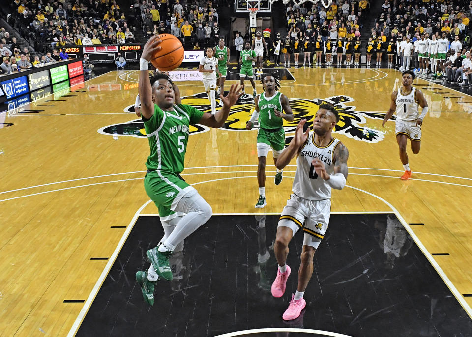 WICHITA, KS - DECEMBER 18:  Tylor Perry #5 of the North Texas Mean Green drives to the basket against Dexter Dennis #0 of the Wichita State Shockers, during the first half at Charles Koch Arena on December 18, 2021 in Wichita, Kansas.  (Photo by Peter G. Aiken/Getty Images)