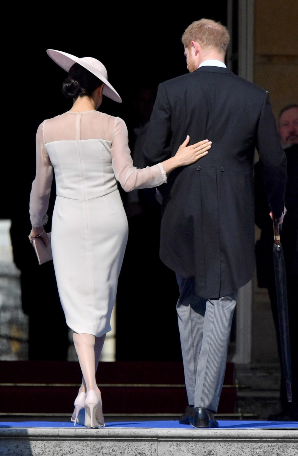 <p>In a sweet sign of affection, Meghan put her arm around her new husband’s back. Photo: Getty </p>