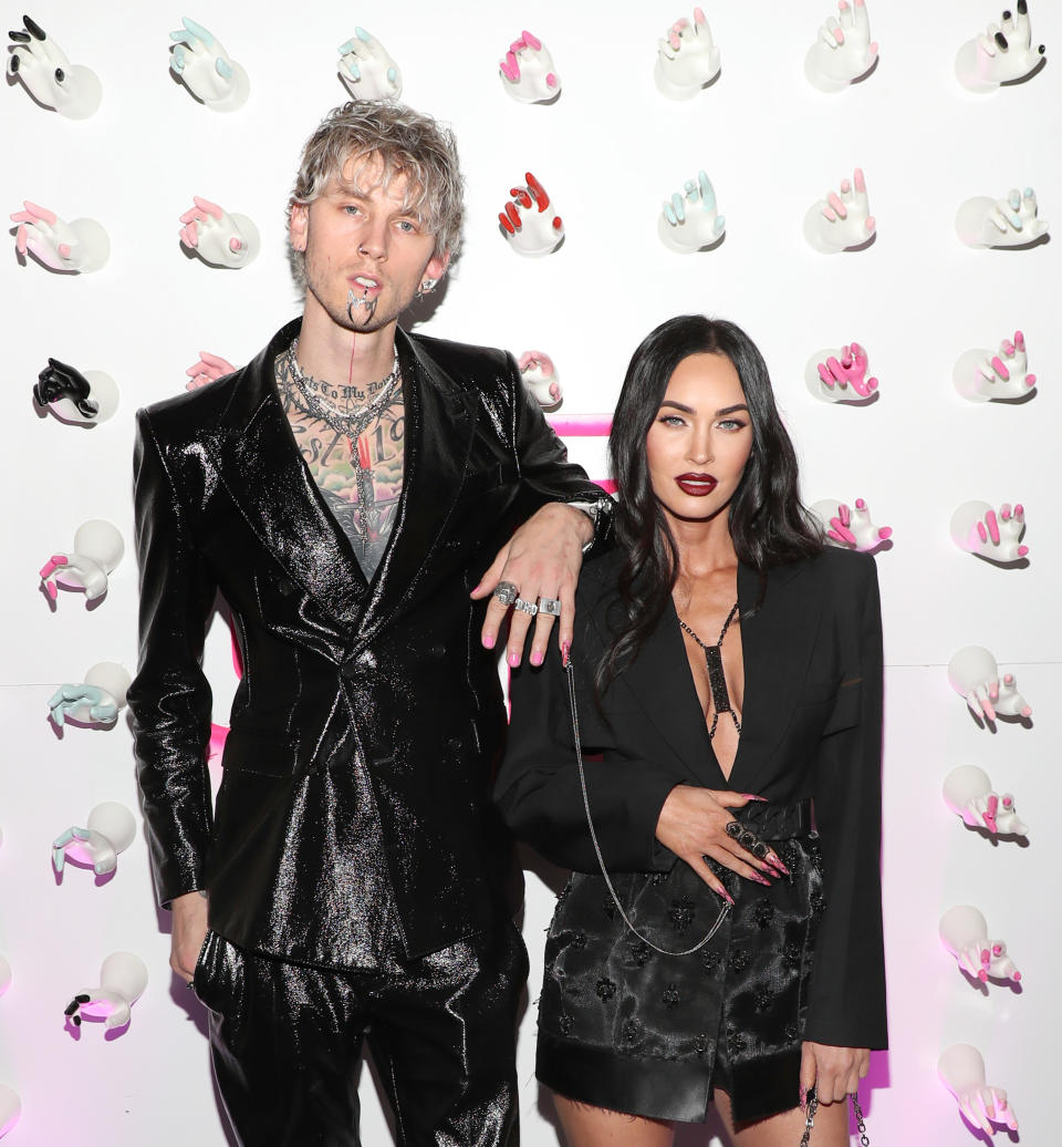 MGK leaning his arm on Megan's shoulder on the red carpet