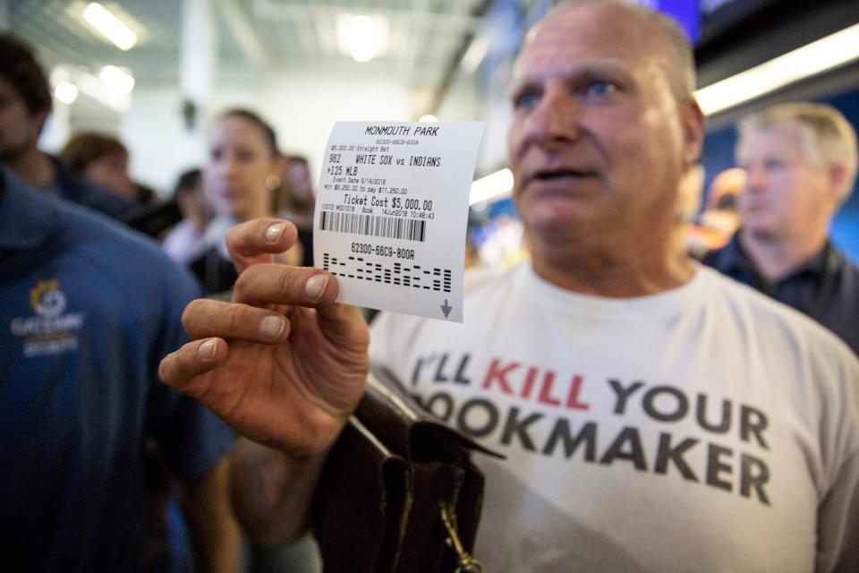 A man holds a betting slip on the first day of legal sports betting in New Jersey on June 14, 2018. <a href="https://www.gettyimages.com/detail/news-photo/professional-odds-maker-stu-feiner-holds-up-a-betting-slip-news-photo/974402508?phrase=sports%20gambling%20new%20jersey&adppopup=true" rel="nofollow noopener" target="_blank" data-ylk="slk:Dominick Reuter/AFP via Getty Images;elm:context_link;itc:0;sec:content-canvas" class="link ">Dominick Reuter/AFP via Getty Images</a>