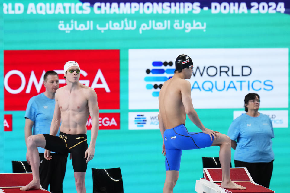 Matt king of the United States, left, and Zhanle Pan of China prepare to compete in the men's 100-meter freestyle heat at the World Aquatics Championships in Doha, Qatar, Wednesday, Feb. 14, 2024. (AP Photo/Hassan Ammar)