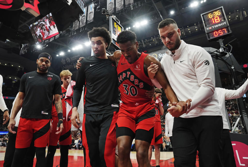 Toronto Raptors guard Ochai Agbaji (30) is helped off the court after an injury during the first half of the team's NBA basketball game against the New York Knicks on Wednesday, March 27, 2024, in Toronto. (Frank Gunn/The Canadian Press via AP)