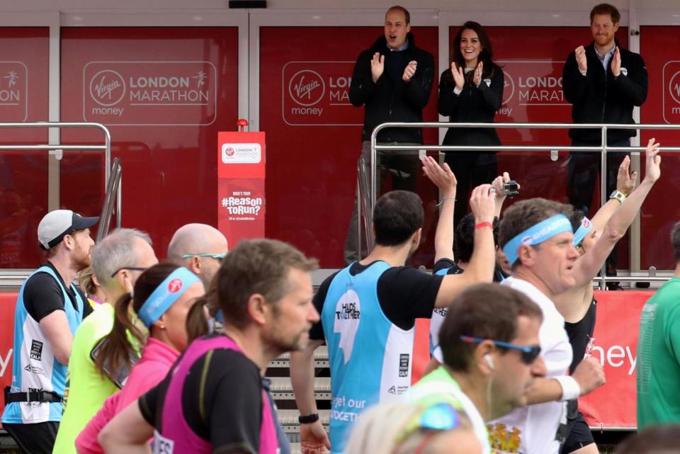 Royal trio: Runners wave at Kate, William and Harry as they pass the finish line (REUTERS)