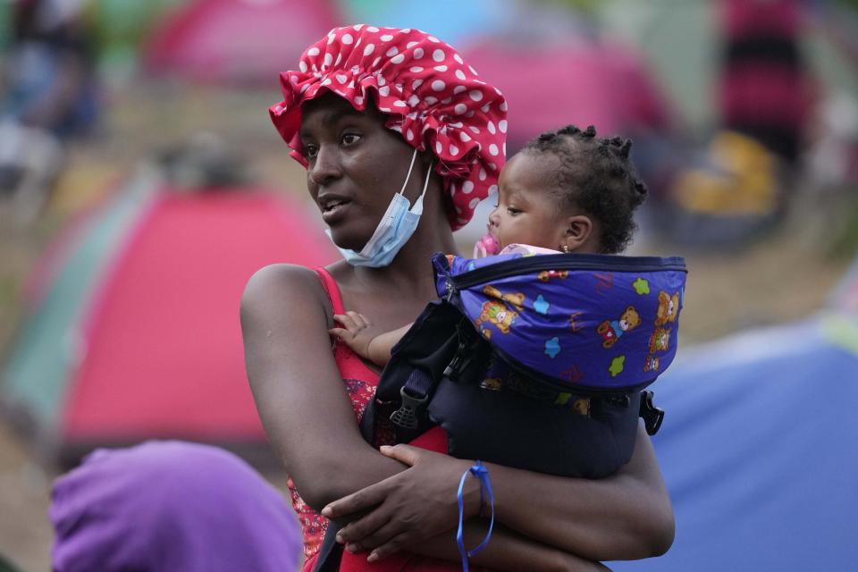 Una migrante sostiene a su hija en un campamento el martes 14 de septiembre de 2021, en Acandí, Colombia. (AP Foto/Fernando Vergara)