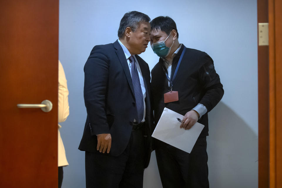 FILE - Liang Wannian, left, then Chinese co-leader of the joint China-WHO investigation into the origins of the COVID-19 pandemic, speaks with a staff member before a press conference in Beijing, March 31, 2021. China's sudden reopening after two years holding to a "zero-COVID" strategy left older people vulnerable and hospitals and pharmacies unprepared during the season when the virus spreads most easily, leading to many avoidable deaths, The Associated Press has found. (AP Photo/Mark Schiefelbein, File)