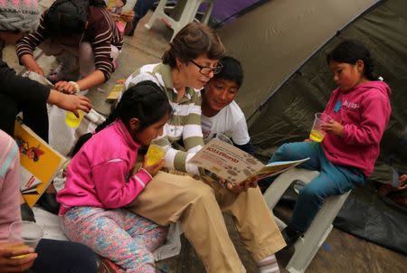 Sister Anne Davis reads books to childs outside the health ministry where residents of the town Cerro de Pasco are protesting what they describe as rampant pollution from a sprawling polymetallic mine operated by Peruvian miner Volcan, in Lima, Peru, June 22, 2017. REUTERS/Mariana Bazo