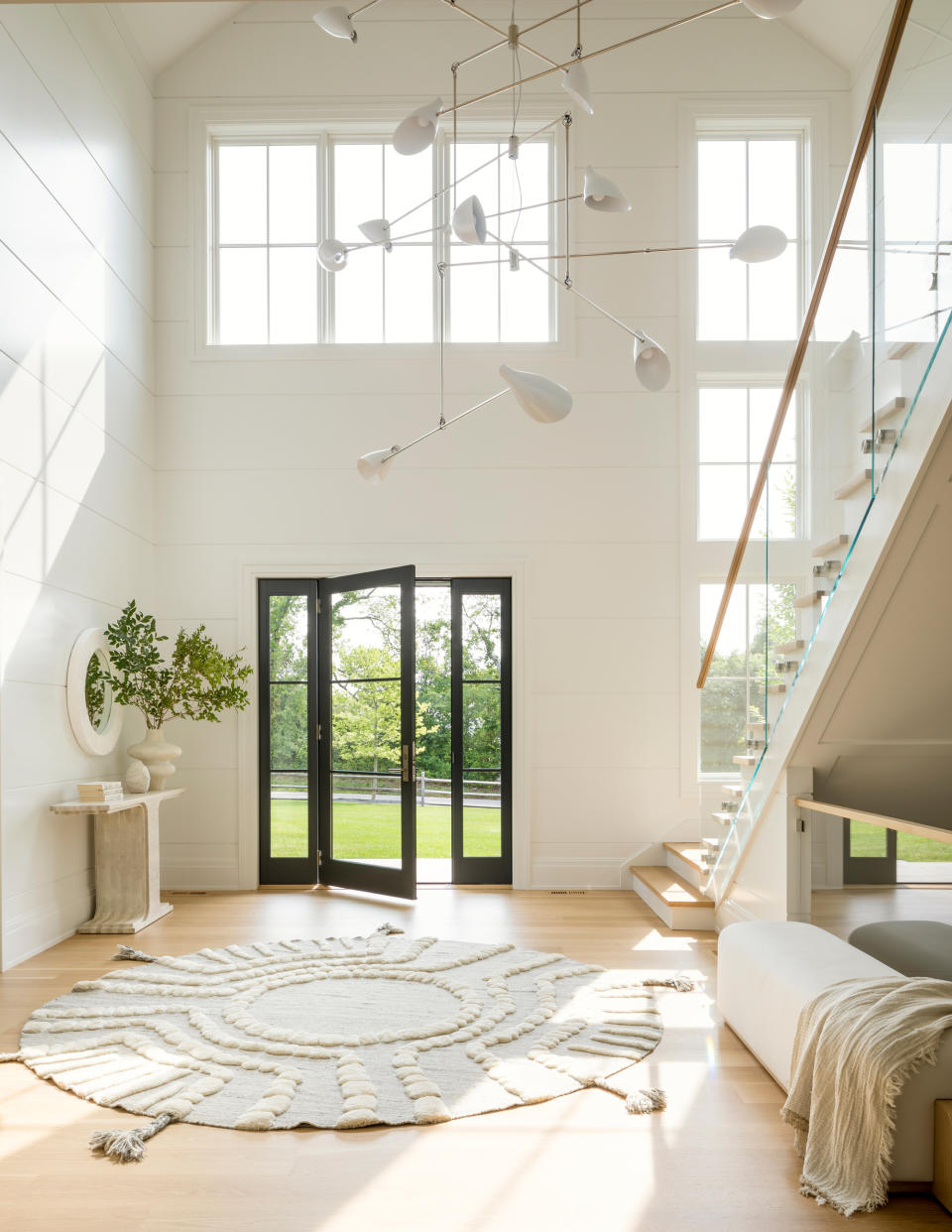 a large neutral entryway with a console table and rug