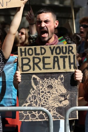 People demonstrate during an Extinction Rebellion protest outside the Brazilian embassy in London