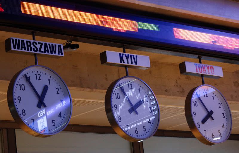 FILE PHOTO: The WIG20 index is seen reflected in clocks showing the time of the different cities in the world at the Warsaw Stock Exchange