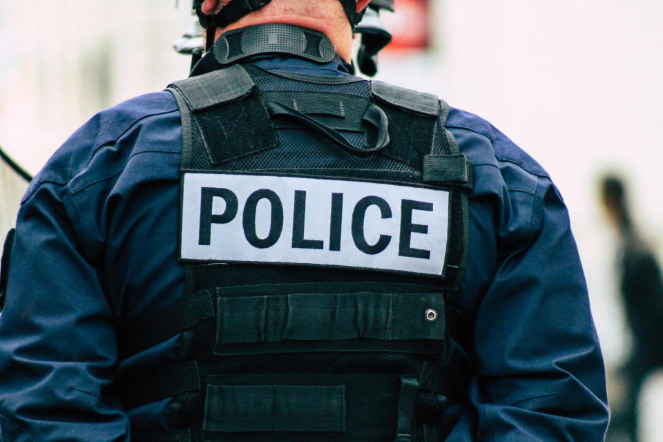 Uniformed person wearing a "Police" sign on his back