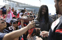 Houston Texans' Jadeveon Clowney, second from right, talks with teammate Duane Brown, right, as they sign autographs for fans after an NFL football training camp practice Sunday, July 27, 2014, in Houston. (AP Photo/David J. Phillip)