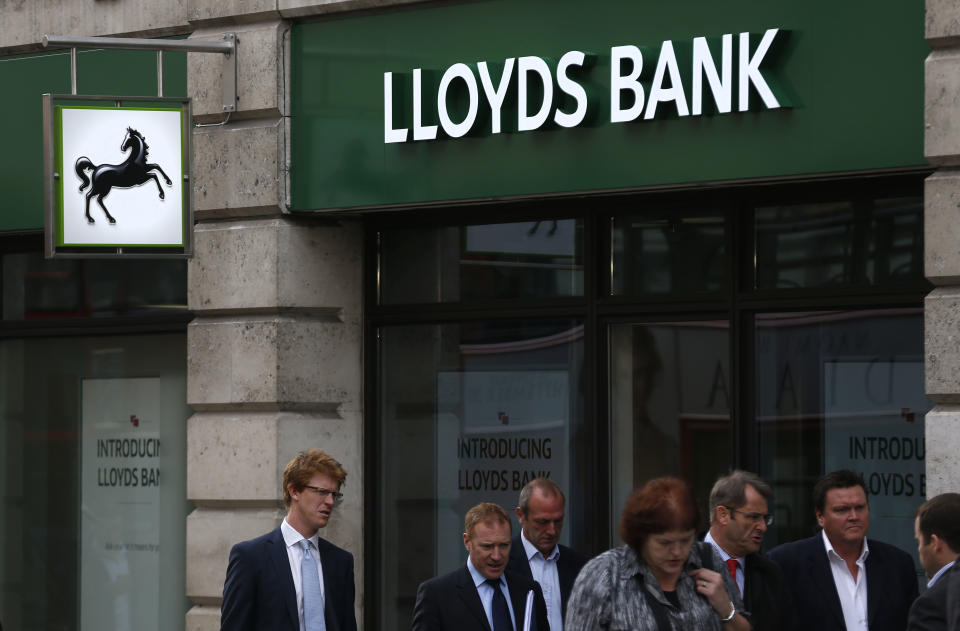 People walk by a branch of Lloyds Bank in the City of London, Tuesday, Sept. 17, 2013. Britain's investment authority says it has begun the privatization of the Lloyds banking group, one of several UK banks bailed out at the height of world financial crisis. Financial Investments, the arm of the British government which manages the country's stakes in Lloyds and the Royal Bank of Scotland, said it was selling 6 percent of Lloyds shares. (AP Photo/Sang Tan)