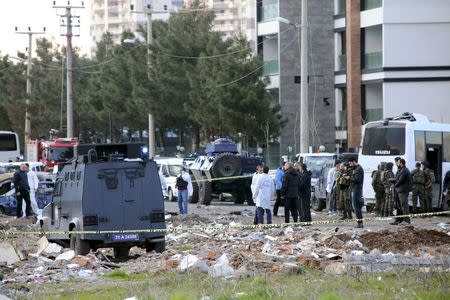 Forensic experts inspect the area after a car bomb attack targeting a minibus carrying members of the police special forces, occurred in the Kurdish-dominated southeastern city of Diyarbakir, Turkey March 31, 2016. REUTERS/Stringer