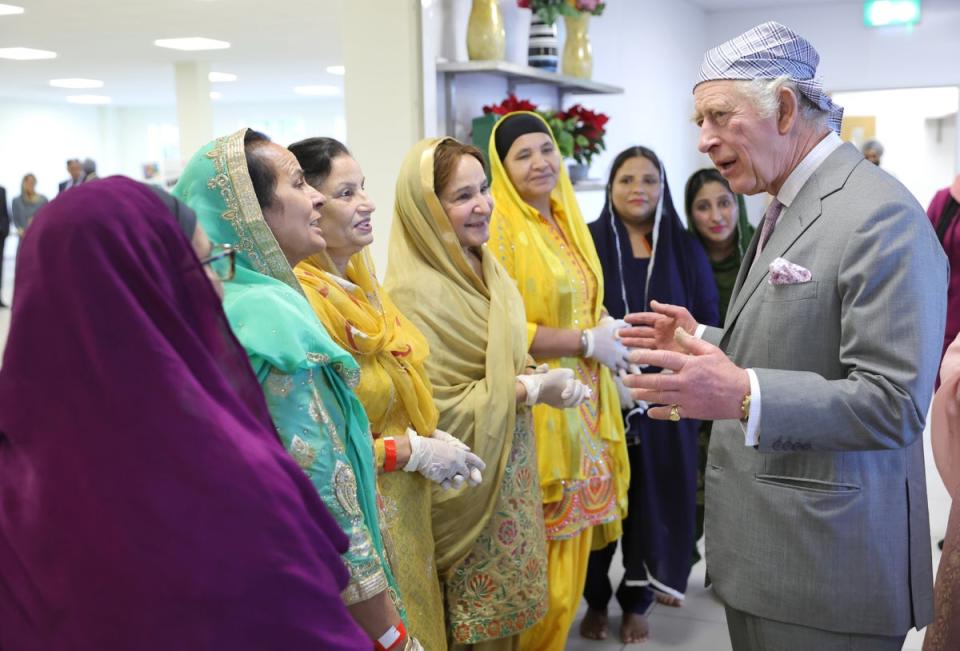 King Charles III smiles as he speaks to volunteers and learns about the programmes they deliver for the local community during a visit to the newly built Guru Nanak Gurdwara (Getty Images)