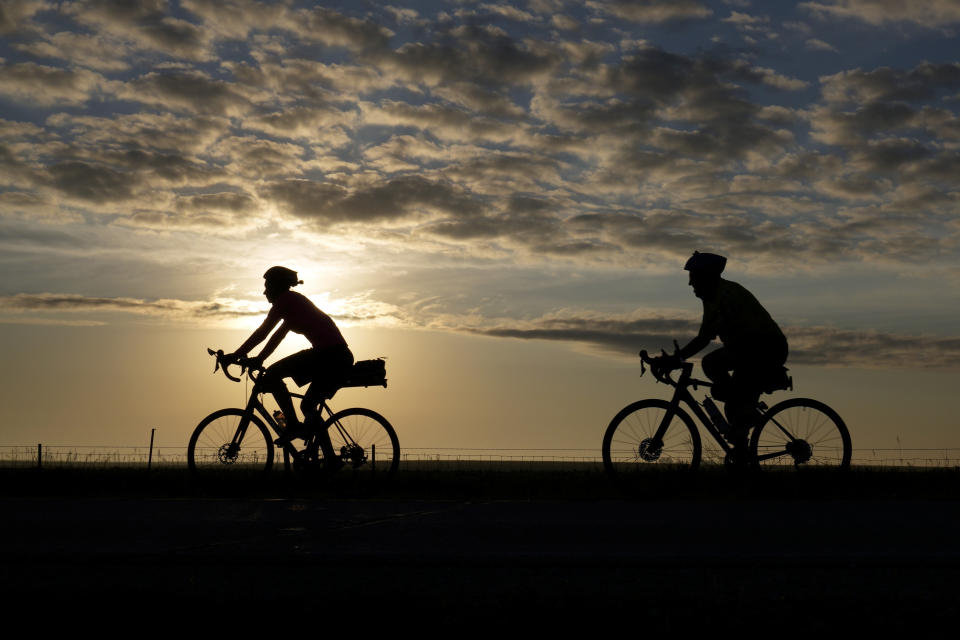 Cyclists make their way on a county highway while riding in The Des Moines Register's annual bike ride across Iowa, also known as RAGBRAI, Tuesday, July 25, 2023, near Scranton, Iowa. (AP Photo/Charlie Neibergall)