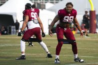 Washington Commanders defensive end Chase Young, right, and defensive end Montez Sweat stretch during an NFL football practice at the team's training facility, Tuesday, Aug. 1, 2023, in Ashburn, Va. (AP Photo/Evan Vucci)