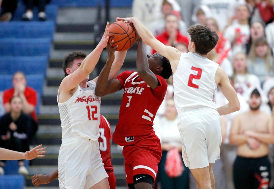 Laingsburg's Jacob Essenberg, right, and Ty Randall, left, block Ecorse's Malik Olafioye, Tuesday, March 21, 2023, at Ypsilanti Lincoln High School.