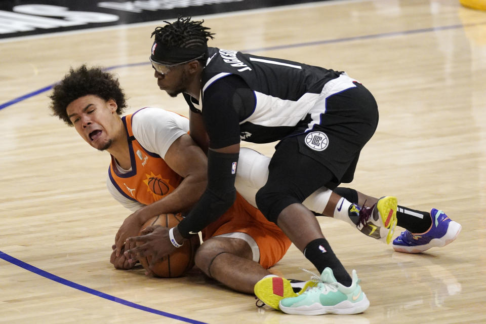 Phoenix Suns forward Cameron Johnson, left, and Los Angeles Clippers guard Reggie Jackson battle for a loose ball during the second half in Game 3 of the NBA basketball Western Conference Finals Thursday, June 24, 2021, in Los Angeles. (AP Photo/Mark J. Terrill)