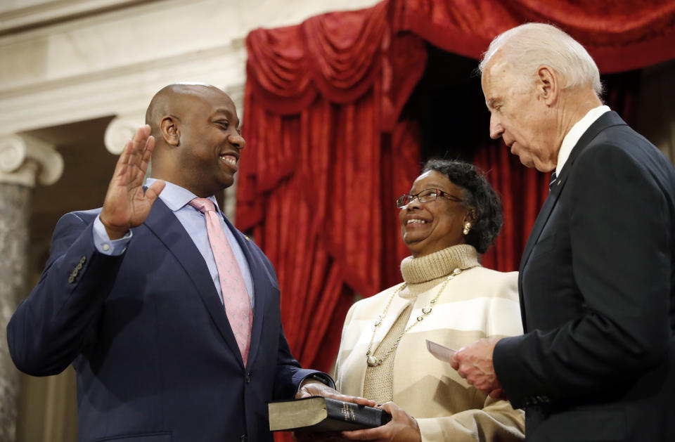 FILE - In this Jan. 3, 2017, file photo, Vice President Joe Biden administers the Senate oath of office to Sen. Tim Scott, R-S.C., as his mother Frances Scott, holds a bible, during a mock swearing in ceremony in the Old Senate Chamber on Capitol Hill in Washington. Initially reluctant to speak on race, Scott is now among the Republican Party’s most prominent voices teaching his colleagues what it’s like to be a Black man in America. (AP Photo/Alex Brandon, File)