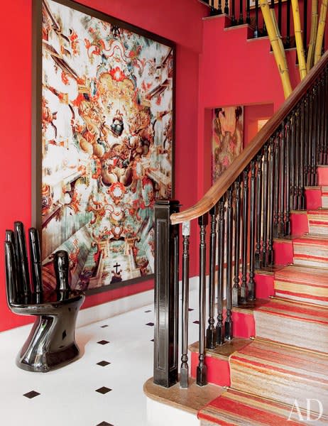 The entrance hall of designer Sig Bergamin’s <a rel="nofollow noopener" href="https://www.architecturaldigest.com/story/sig-bergamin-sao-paulo-brazil-home-article?mbid=synd_yahoo_rss" target="_blank" data-ylk="slk:São Paulo, Brazil, home;elm:context_link;itc:0;sec:content-canvas" class="link ">São Paulo, Brazil, home</a> sets the tone for the eclectic interiors within. The vibrant walls and staircase compliment a Caio Reisewitz C-print and a Pedro Friedeberg hand chair.