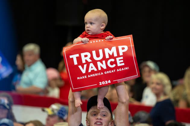 A man lifts a baby holding a 