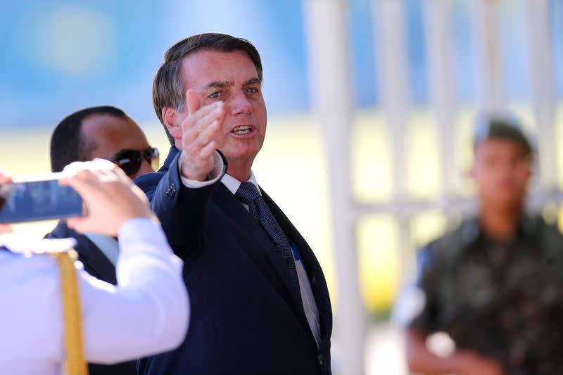 Brazil's President Jair Bolsonaro gestures while meeting supporters as he leaves Alvorada Palace, amid coronavirus disease (COVID-19) outbreak, in Brasilia