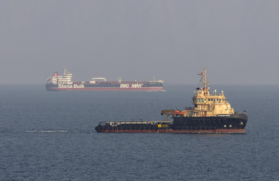 In this image taken from aboard a Royal Navy Wildcat helicopter patrolling the Gulf as part of the International Maritime Security Construct, shows the MV Stena Impero, background, as it sails from the port at Bandar Abbas, Iran, after being released by Iranian officials Friday Sept. 27, 2019. Iran on Friday released the British-flagged oil tanker it had seized in July 2019, while the country’s president, returning from an annual United Nations meeting, said he had been told the United States had offered to lift sanctions if Tehran returned to the negotiating table over its nuclear program. (Dan Rosenbaum/British Royal Navy via AP)