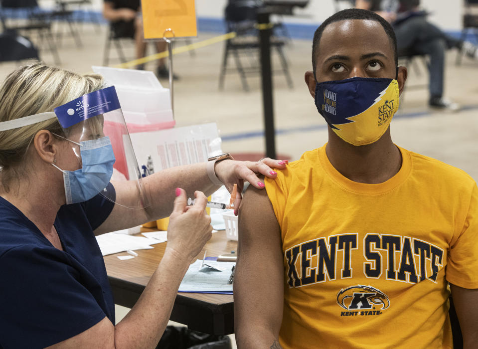 Kent State University student Marz Anderson gets his Johnson & Johnson COVID-19 vaccination from Kent State nurse Beth Krul in Kent, Ohio, Thursday, April 8, 2021. U.S. colleges hoping for a return to normalcy next fall are weighing how far they should go in urging students to get the COVID-19 vaccine, including whether they should — or legally can — require it. (AP Photo/Phil Long)