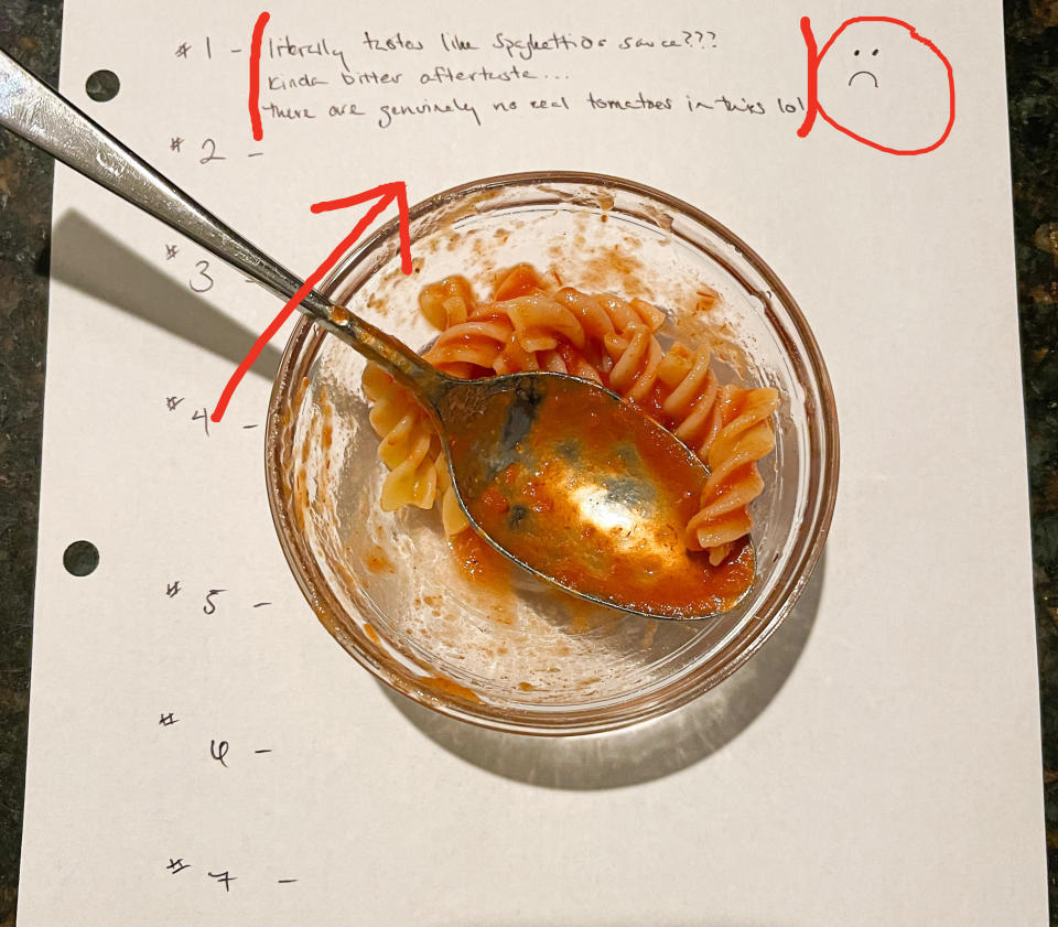 Small bowl of sauced pasta on top of a piece of paper with notes: "#1: literally tastes like SpaghettiOs sauce??? kinda bitter aftertaste...there are genuinely no real tomatoes in this lol" and a frown face drawn next to it