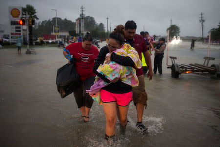 A family arrives to high ground after they fled their home due to floods caused by Tropical Storm Harvey along Tidwell Road in east Houston, Texas, U.S. August 28, 2017. REUTERS/Adrees Latif