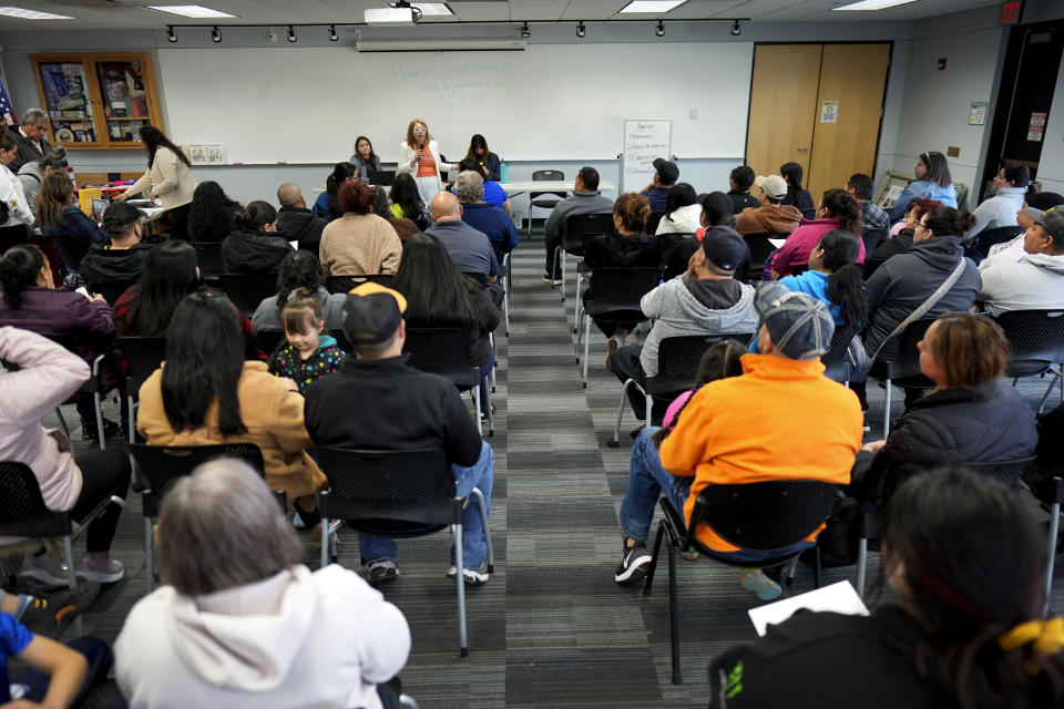 Audience members listen to community organizer Maria Acosta speak during an Iowa Migrant Movement for Justice informational meeting, Wednesday, March 27, 2024, in Des Moines, Iowa. A bill in Iowa that would allow the state to arrest and deport some migrants is stoking anxiety among immigrant communities about how it would be interpreted and enforced. (AP Photo/Charlie Neibergall)