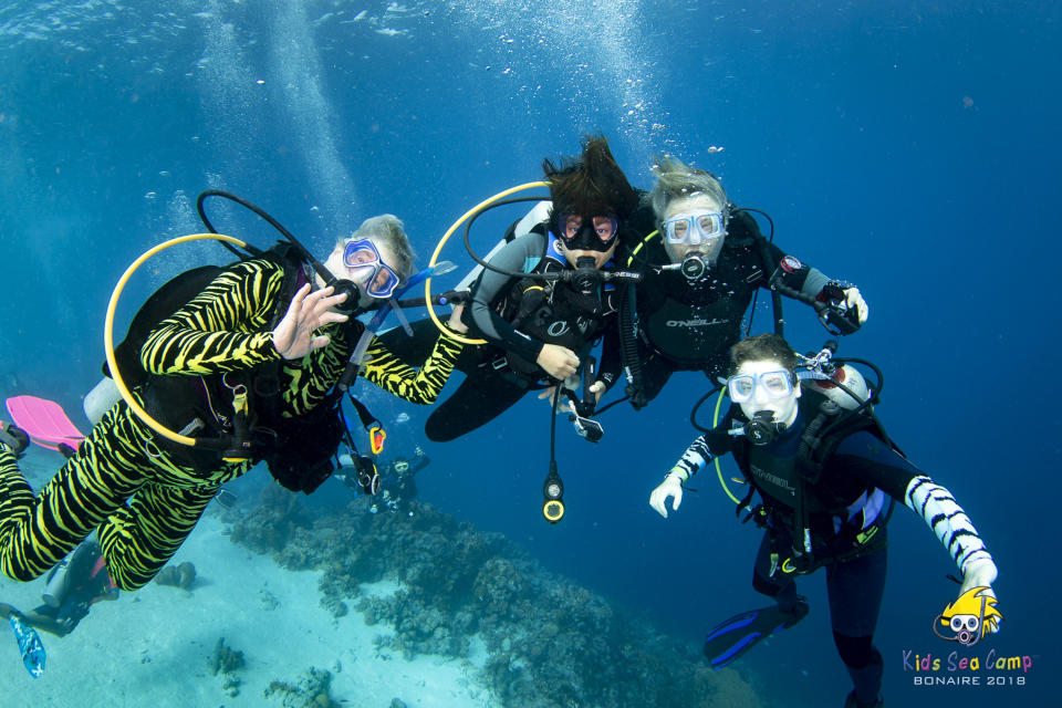 This November 2018 photo provided by Margo Peyton shows, from left, Diana Ademic, Berenice Felipa, Steve Salika and Tia Salika enjoying a dive during their 2018 Thanksgiving vacation trip at a Kids Sea Camp week at Buddy Dive Resort off Bonaire, a Netherlands-administered island in the Leeward Antilles off the coast of Venezuela. All four were aboard the dive boat Conception and all died in the fire that swept the vessel on Sept. 2, 2019 off the coast of Southern California. (Margo Peyton via AP)