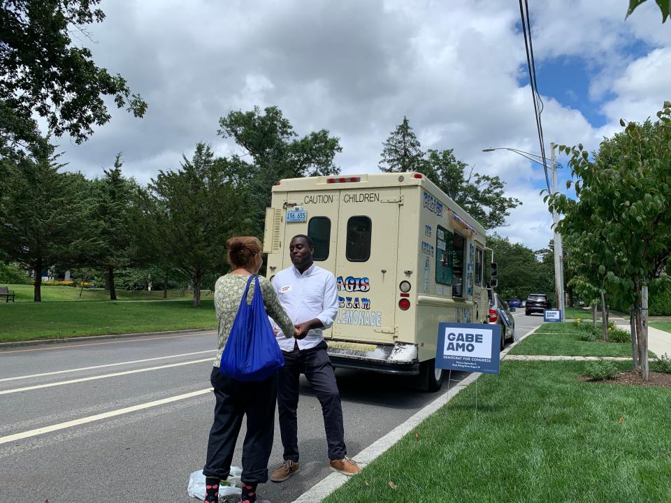 Gabe Amo speaks with a voter on Blackstone Boulevard in Providence, where he was offering free ice cream.